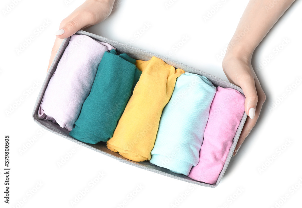 Female hands with clean clothes in organizer on white background