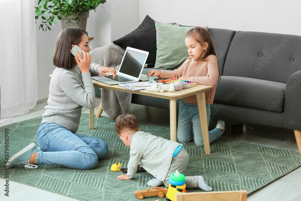 Working mother with little children at home