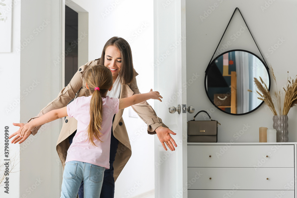 Happy daughter meeting her mother after work at home