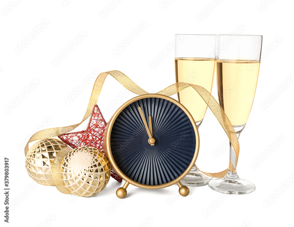 Alarm clock, Christmas decor and glasses of champagne on white background