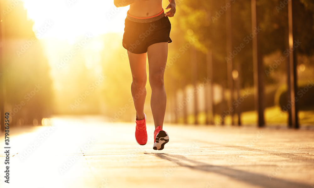 Anonymous sportswoman running in park.