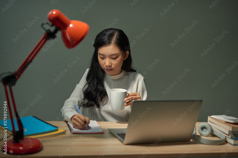 Smiling Asian girl having online classes at home