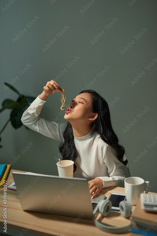 饥饿的学生在家学习时吃面条