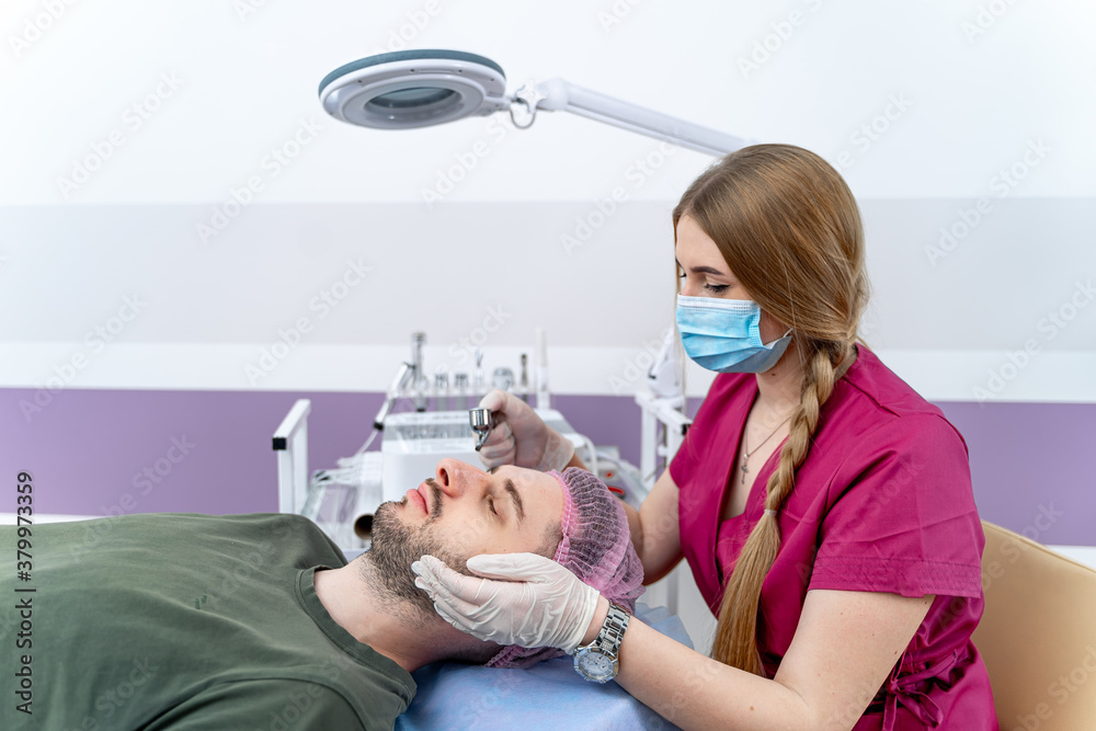 Man getting facial procedure by beautician at spa salon. Beauty treatment and skincare. Closeup.