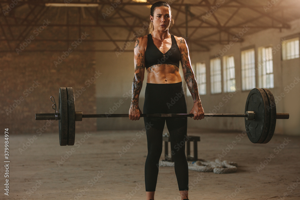 Woman doing deadlift workout with barbell