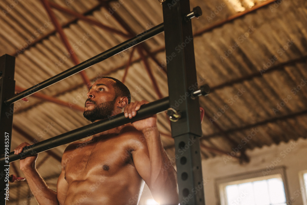 Muscular man doing pull up workout