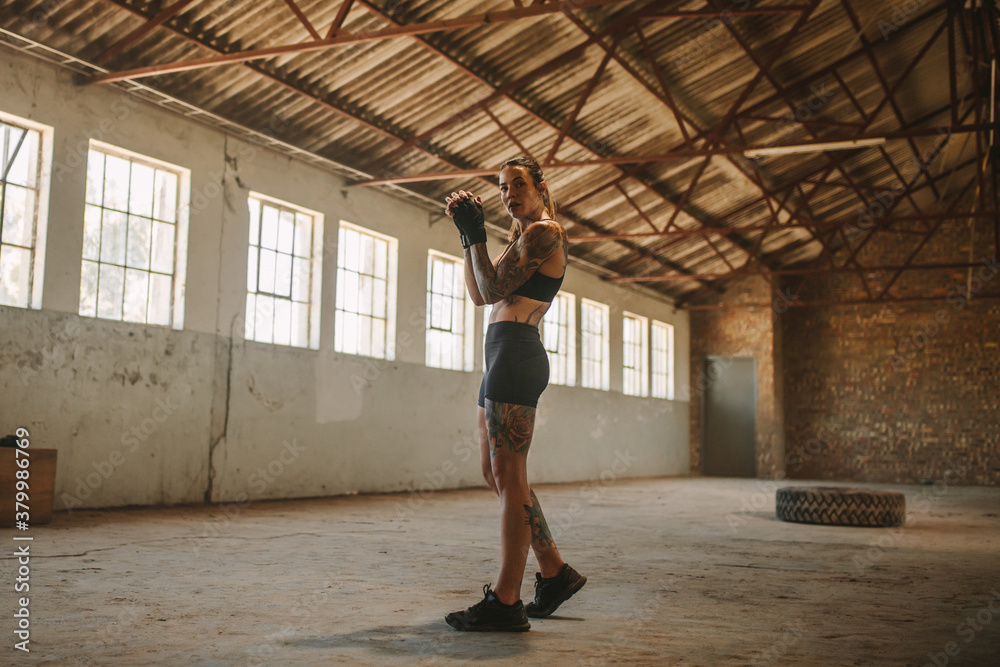 Woman shadow boxing in empty warehouse