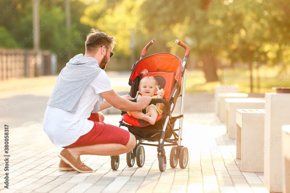 Man and his cute baby in stroller outdoors