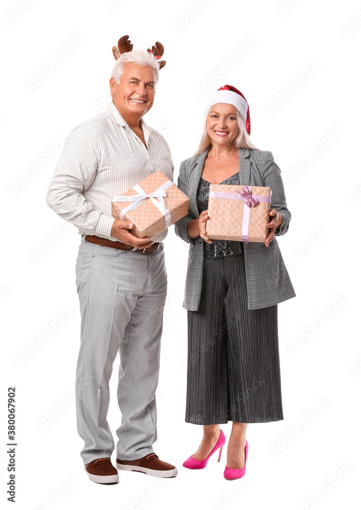 Elderly couple with Christmas gifts on white background