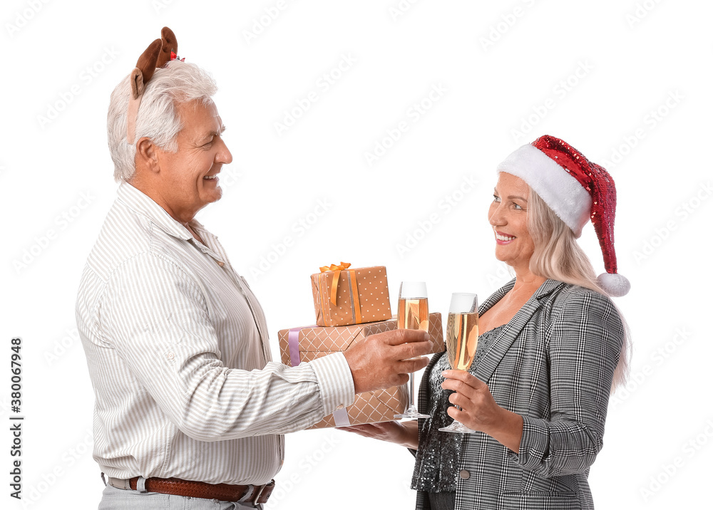 Elderly couple with Christmas gifts and champagne on white background