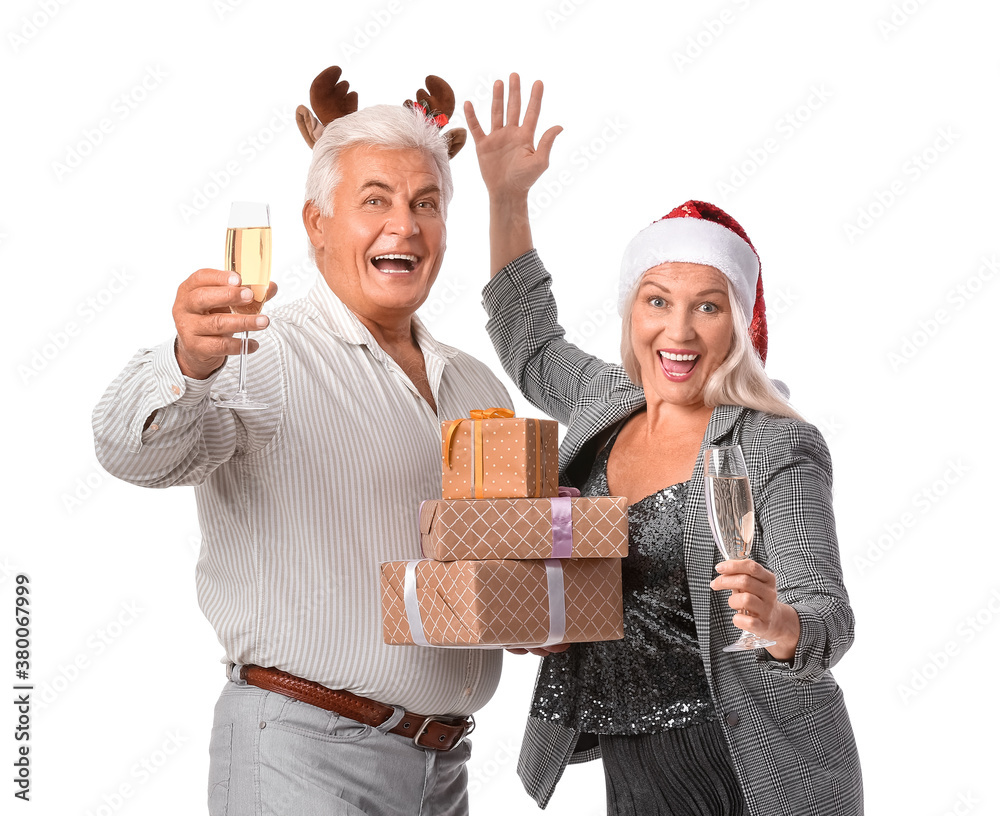 Elderly couple with Christmas gifts and champagne on white background