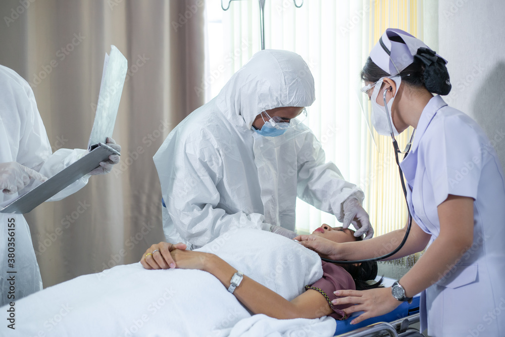 Emergency paramedic doctor in PPE suit and medical mask or face shield and female nurse having first