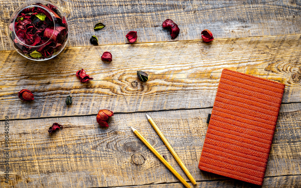 orange notebook with flower on wooden table