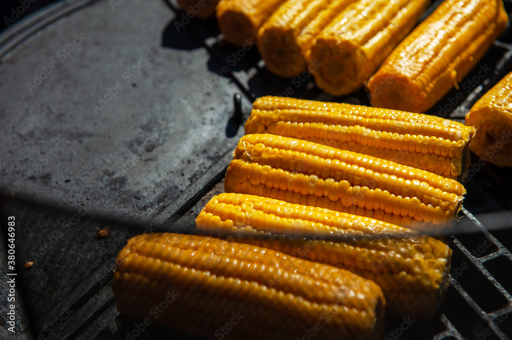 A professional cook prepares corn on the grill outdoor, food or catering concept