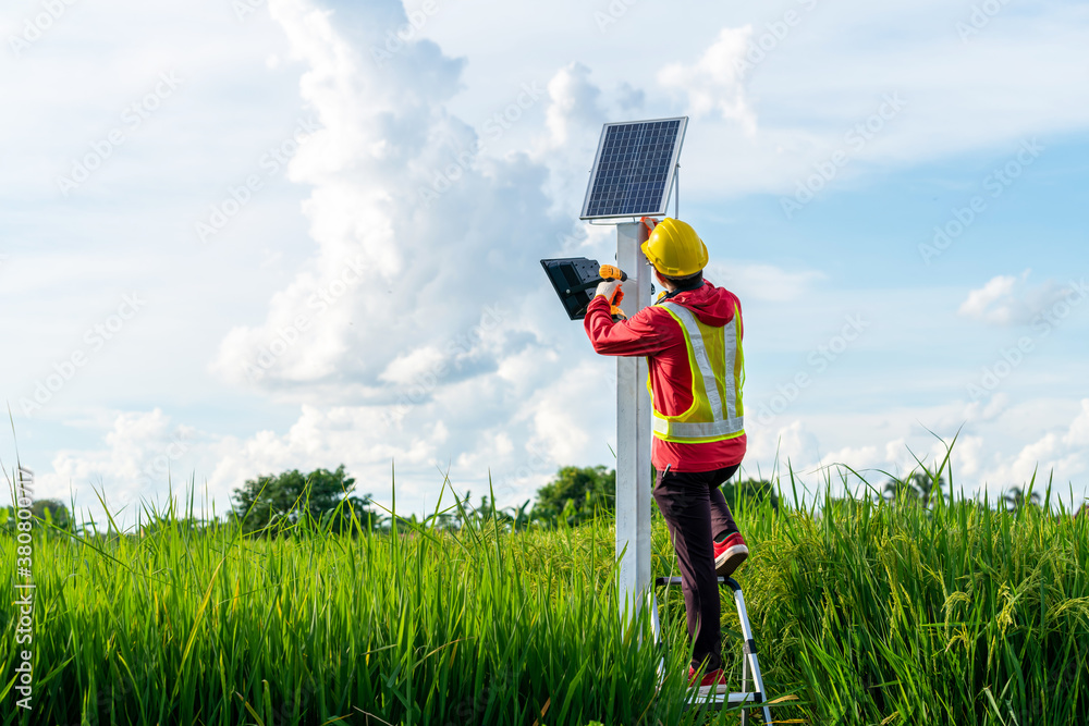 Asian technician install the maintenance of the solar panels, outdoor lighting pole with small solar