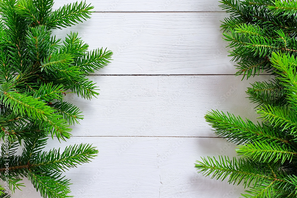 Fir / pine borders on white wooden background. Top view of Christmas frame, place for your text or p