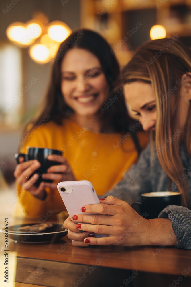 Friends using a smart phone at coffee shop