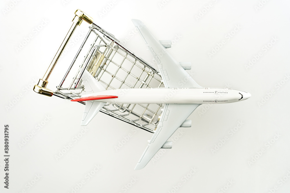 Airplane model in shopping cart on white background.