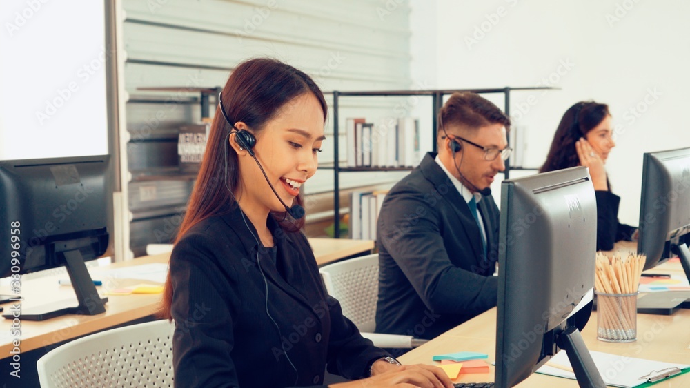 Business people wearing headset working in office to support remote customer or colleague. Call cent