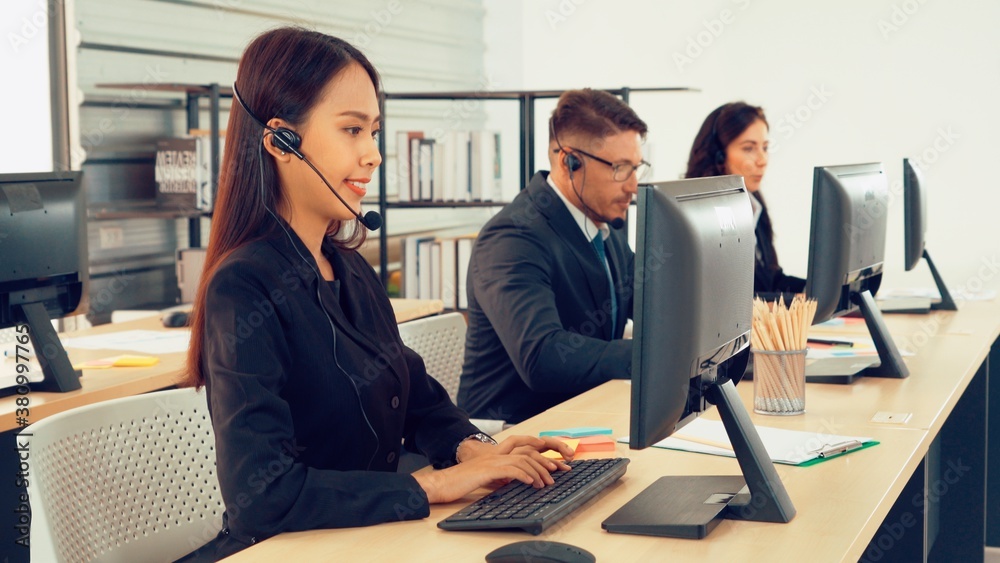 Business people wearing headset working in office to support remote customer or colleague. Call cent