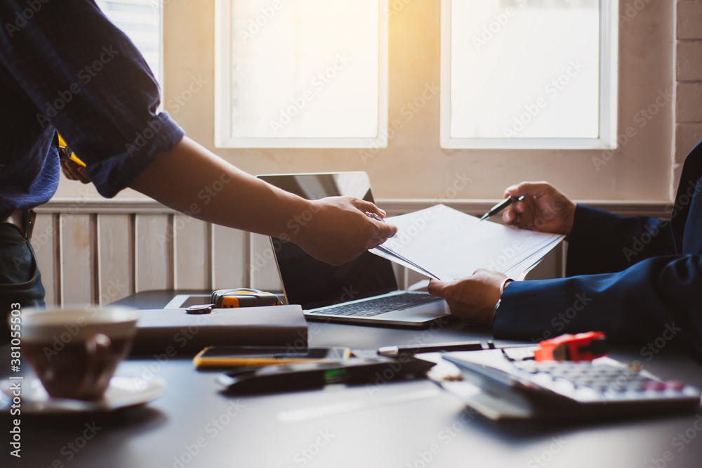 Engineers work to discuss projects at their desks in the office.