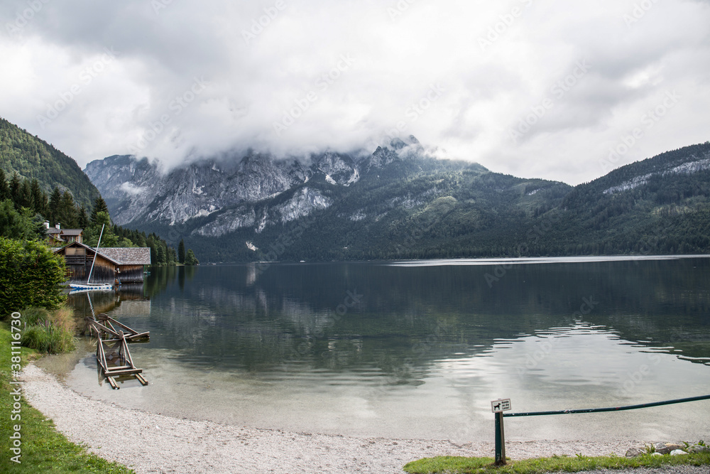 Lakeside bank under misty mountains