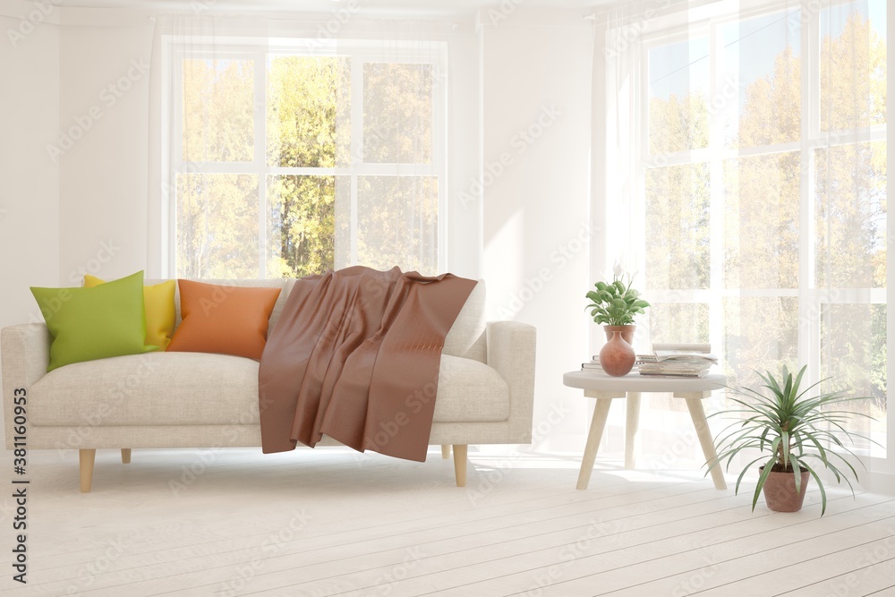 Stylish room in white color with sofa and autumn landscape in window. Scandinavian interior design. 