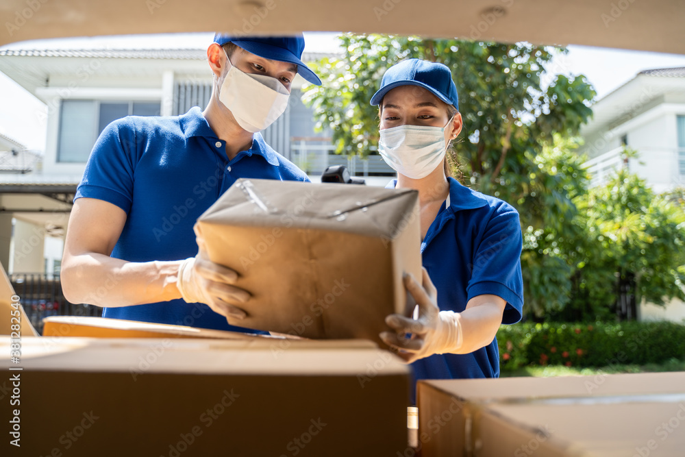 Asian young delivery man and woman preparing box of parcels to deliver