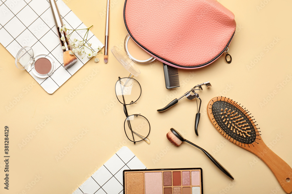 Makeup bag with decorative cosmetics and accessories on color background