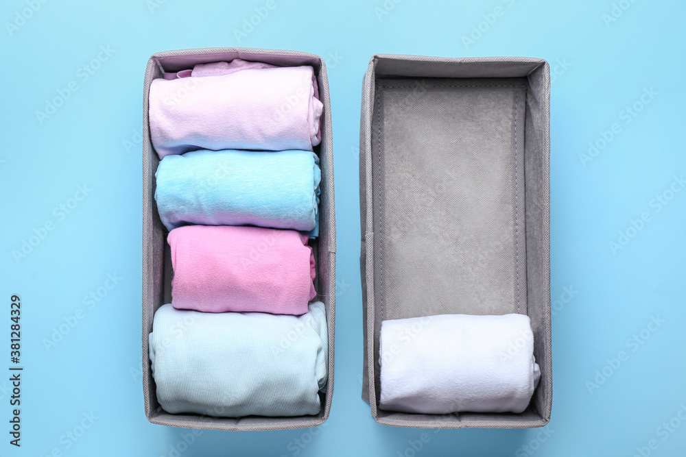 Organizers with clean clothes on color background