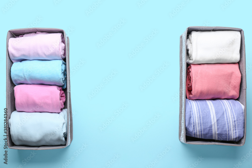 Organizers with clean clothes on color background