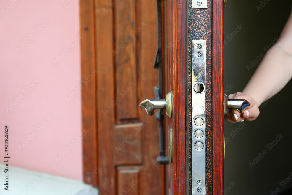 Woman opening door outdoors, closeup