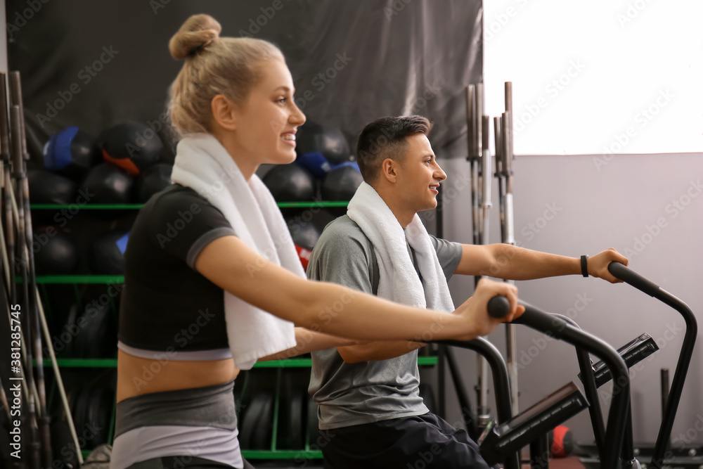 Young people training on exercising bike in gym