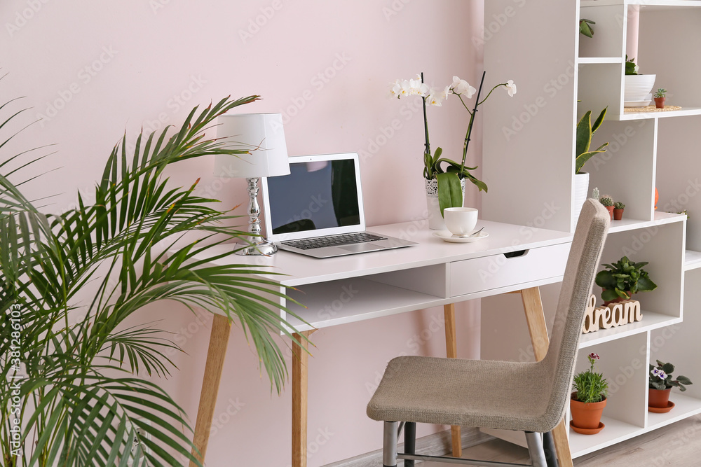 Stylish interior of room with green houseplants and workplace