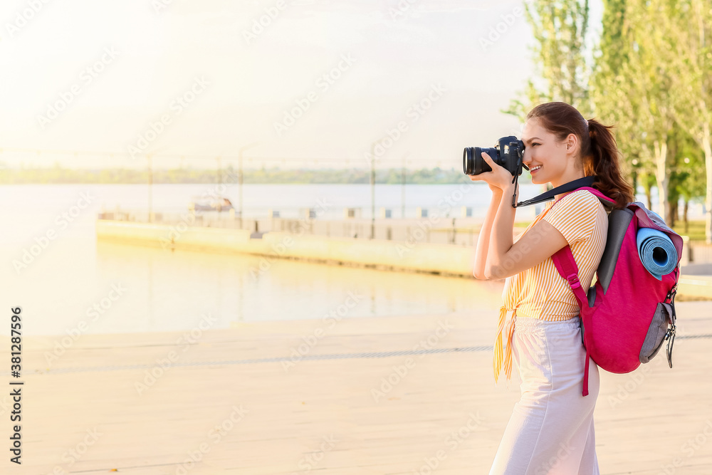 Female tourist taking photo on city street