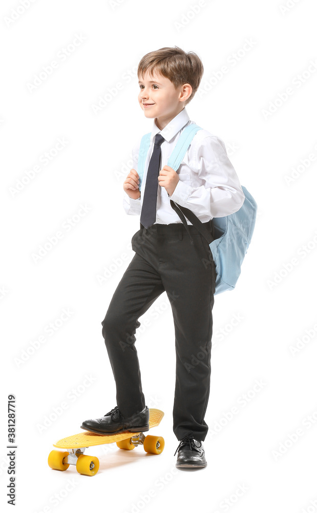 Little schoolboy with skateboard on white background