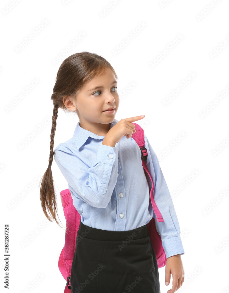 Little schoolgirl pointing at something on white background