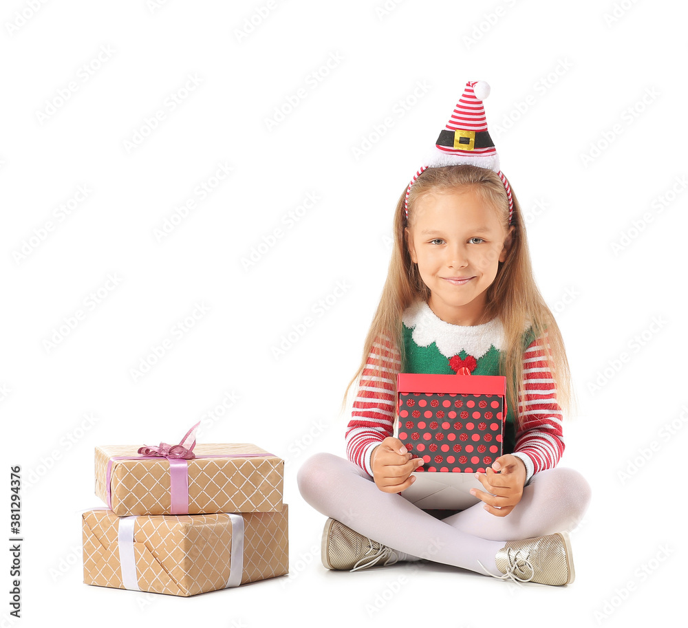 Cute little girl dressed as elf and with Christmas gifts on white background