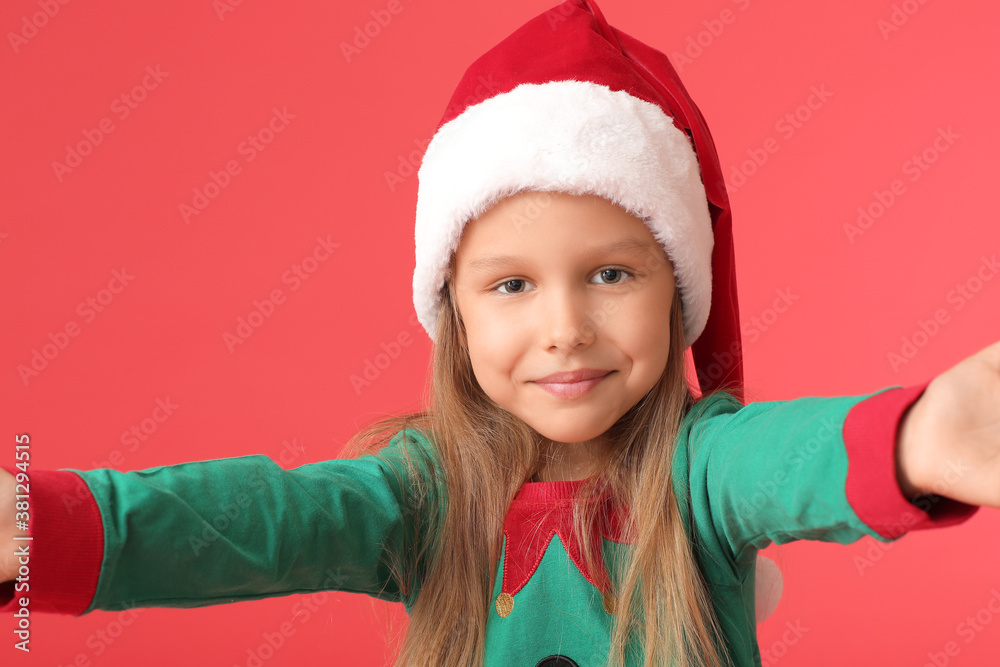 Cute little girl dressed as elf on color background