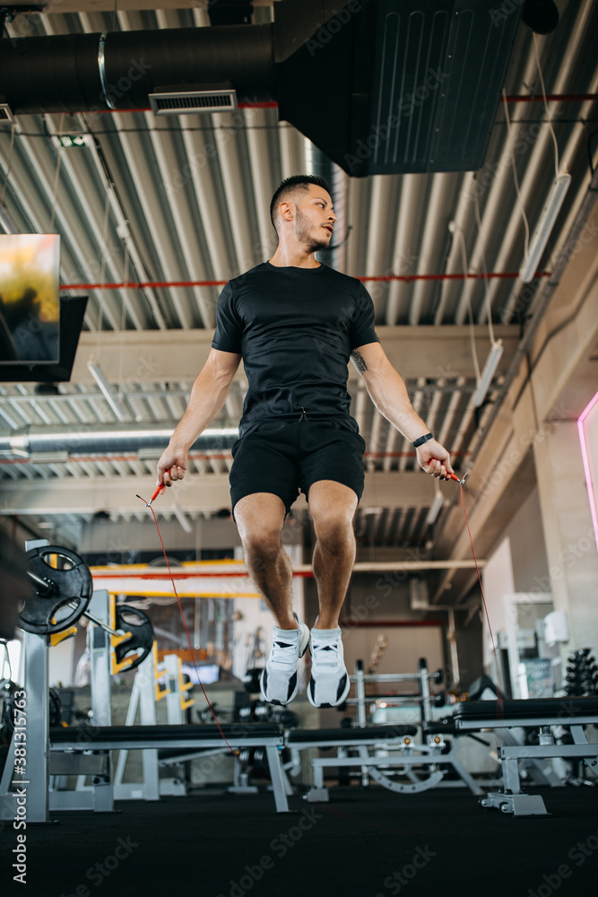 Muscular man skips the jump rope.