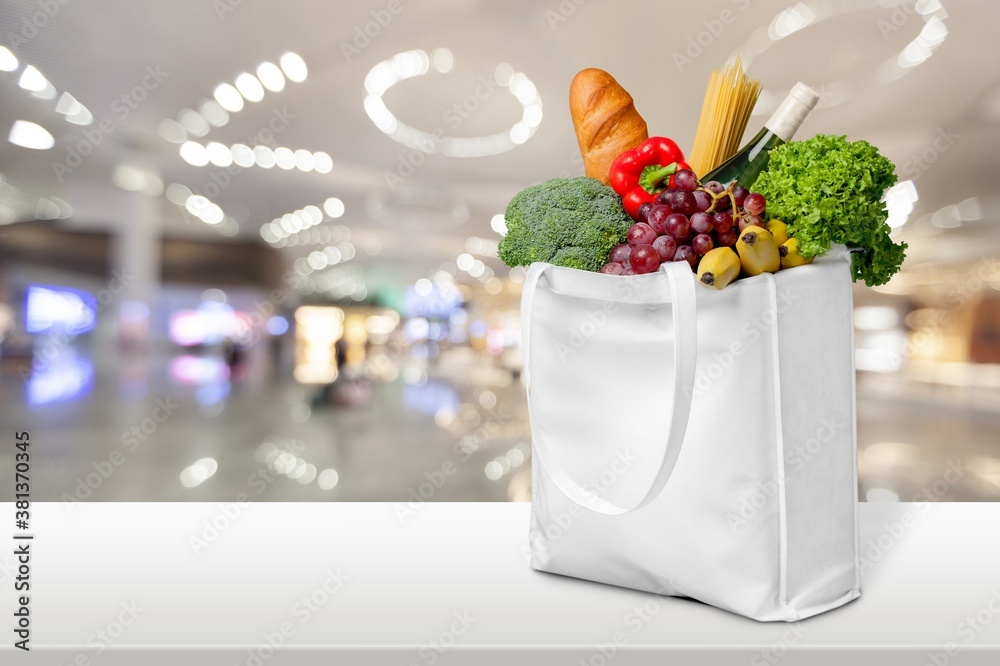 Full shopping bag with various vegetables and groceries