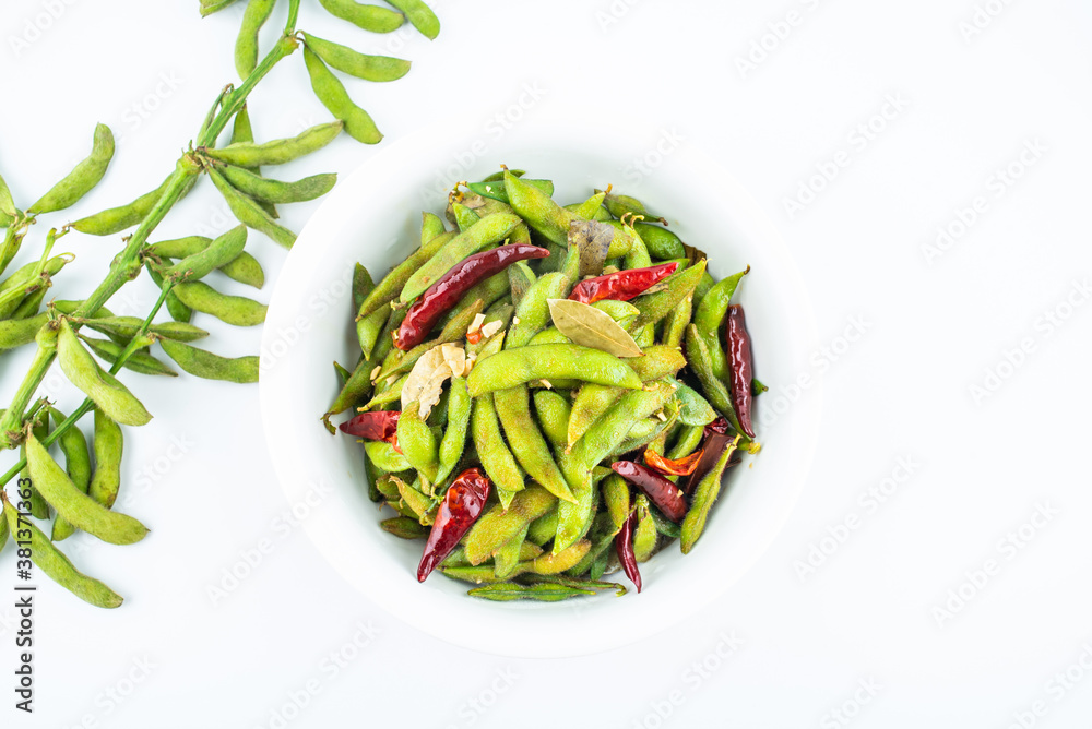 A pot of delicious spicy edamame on white background