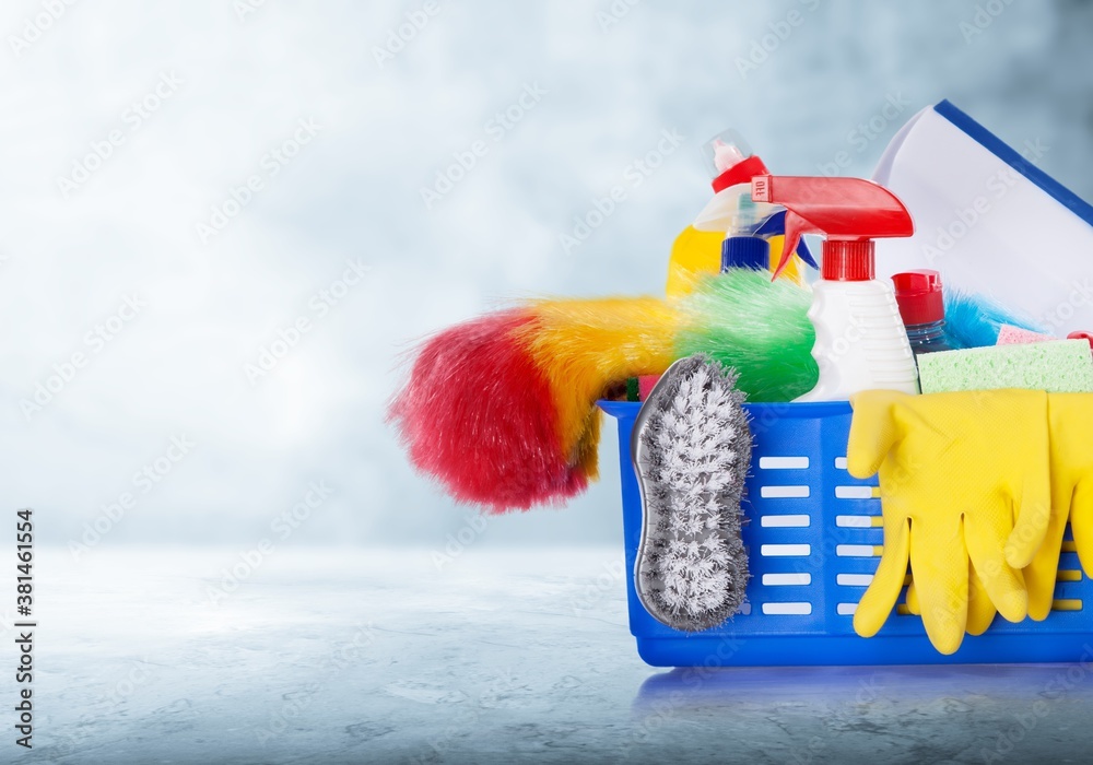 Cleaning supplies in a plastic bucket on desk