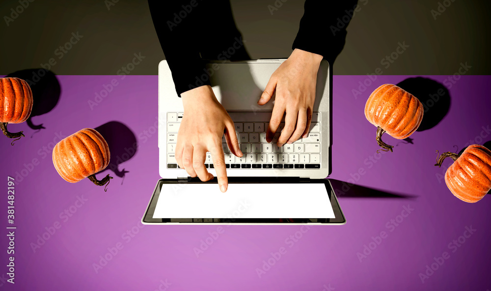 Autumn pumpkins with person using a laptop computer from above