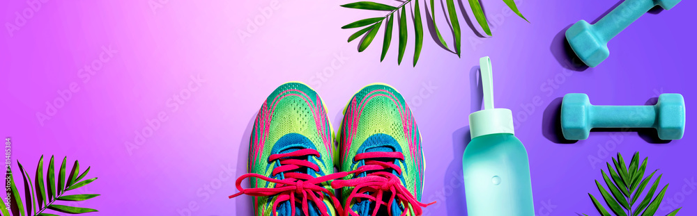 Fitness shoes and dumbbells with tropical plants - flat lay