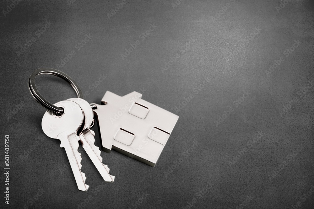 House shaped keychain and keys on desk