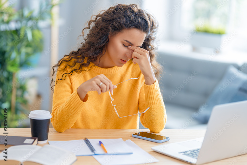 Young woman studying and having a head ache