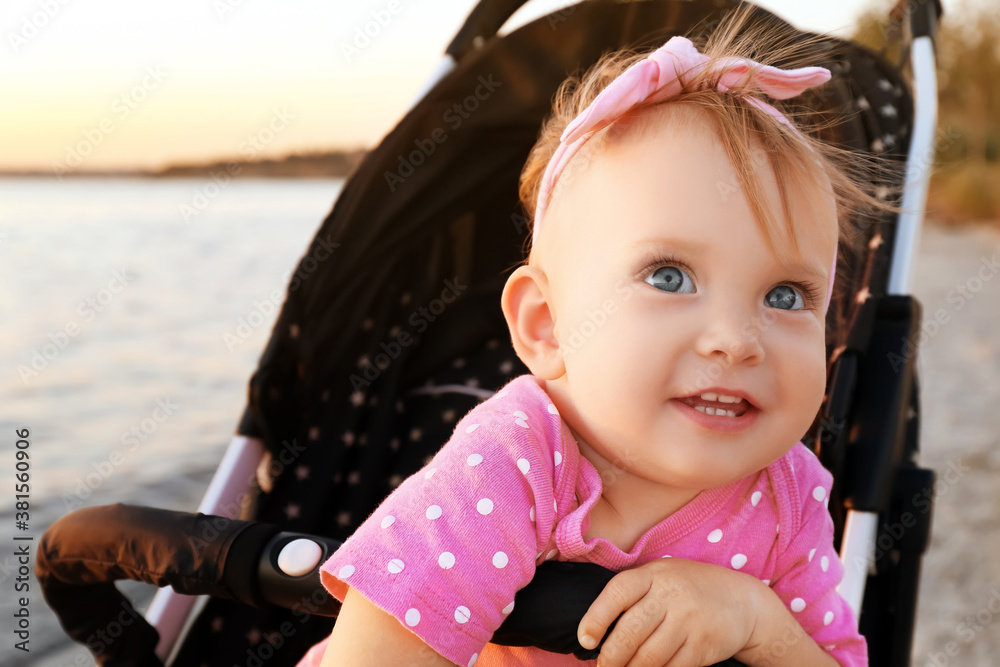 Cute baby in stroller near river