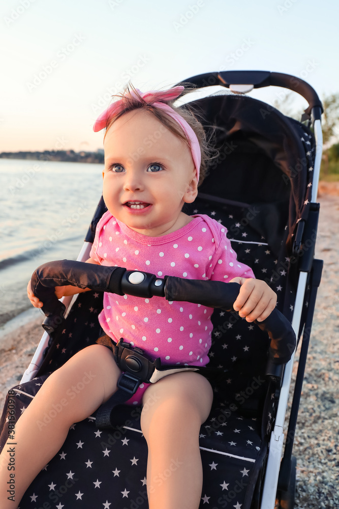 Cute baby in stroller near river