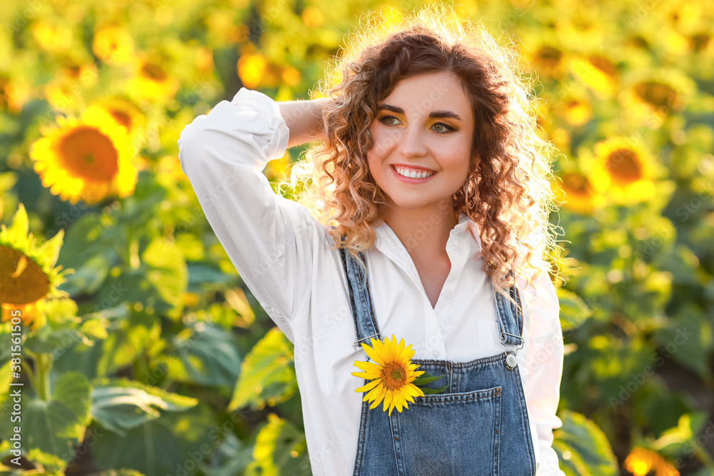 Beautiful young woman in sunflower field